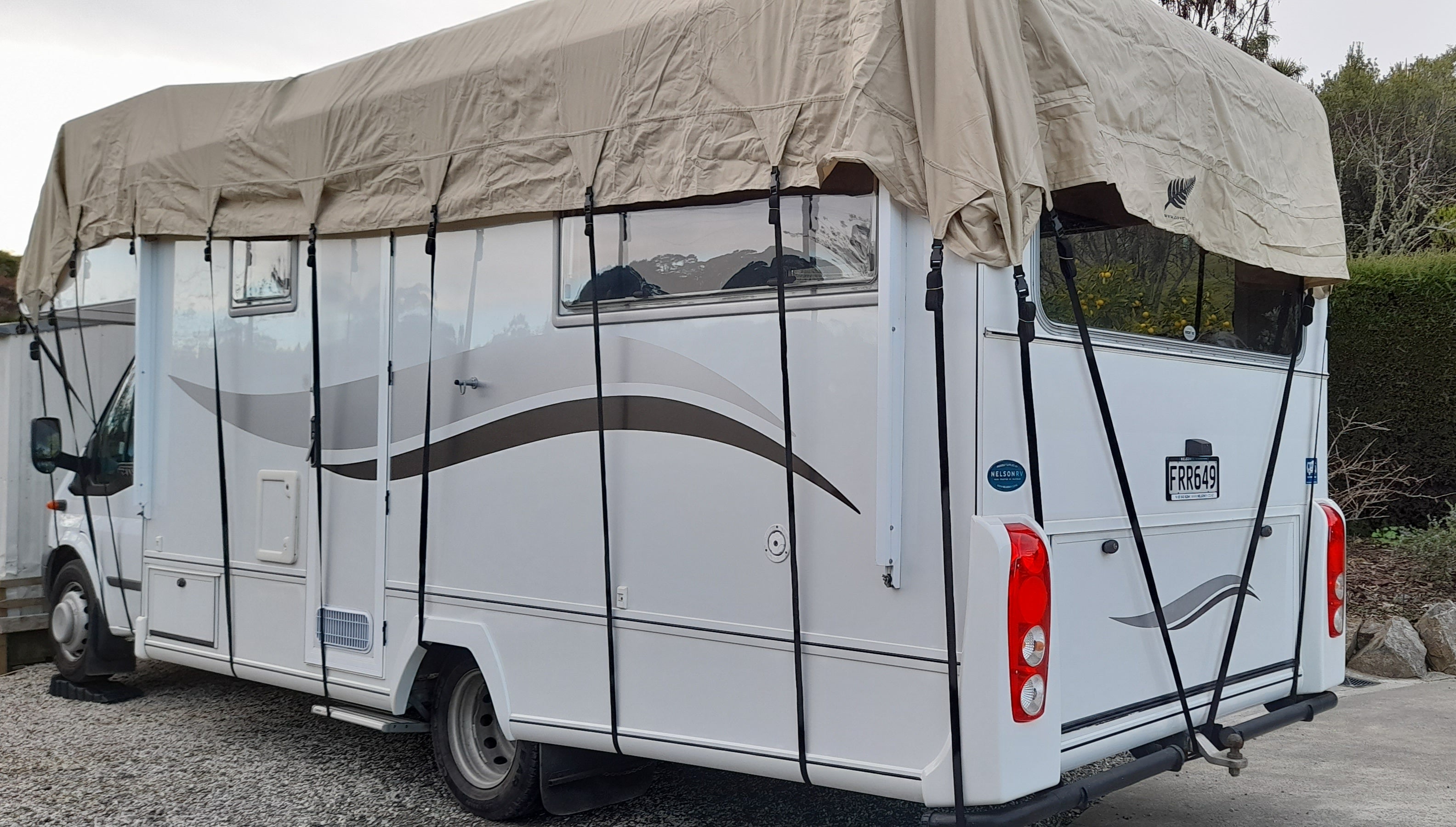 image of ack of motorhome roof cover with black tie down straps.