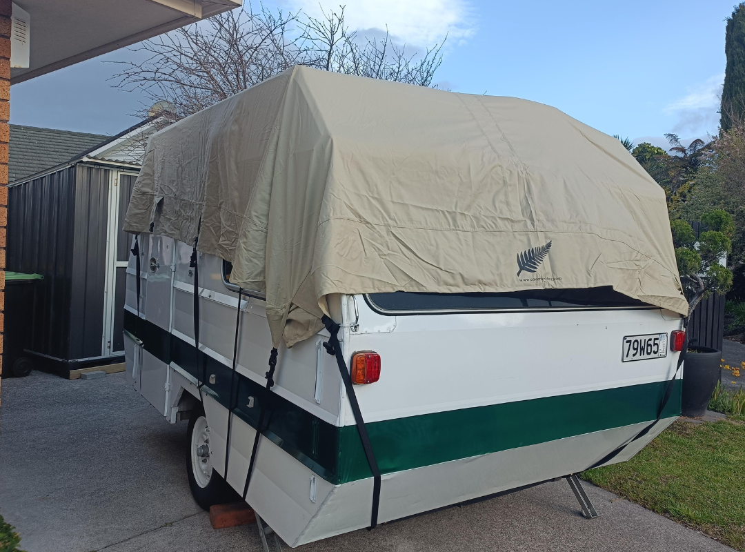 Image of vinatge retro carvan with roof cover on to protect from leaks.